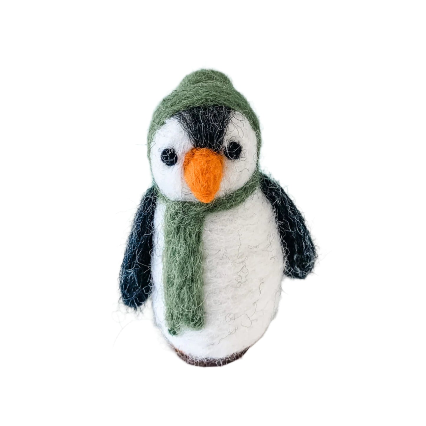 Knitted penguin toy with a green hat and scarf on a white surface with a light blue background