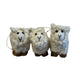 Three small white sheep figurines on a gray surface