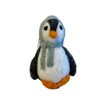 Small felted penguin toy with a gray scarf on a light gray background